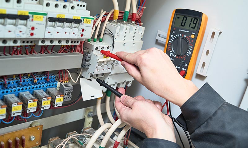 A technician checking an electrical circuit breaker
